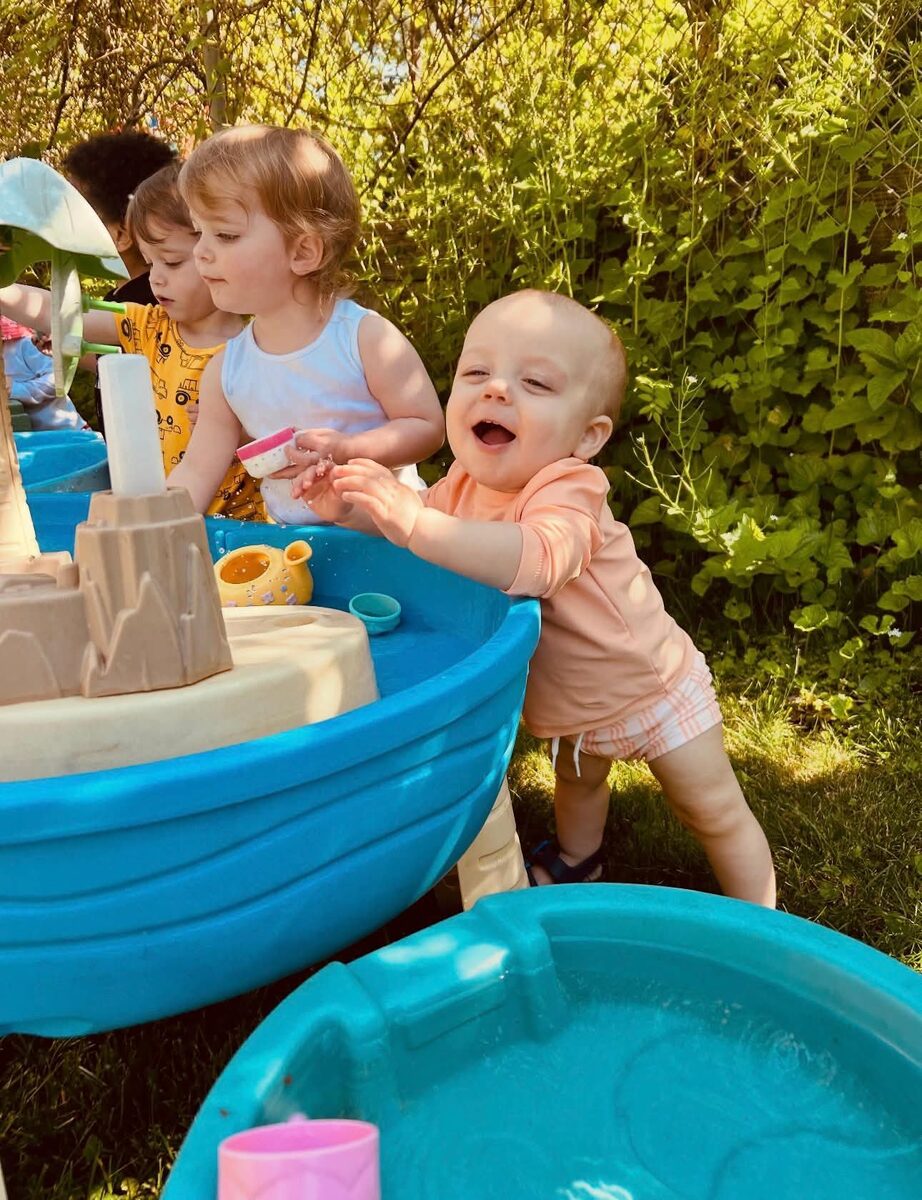 Toddler laughing at the water table